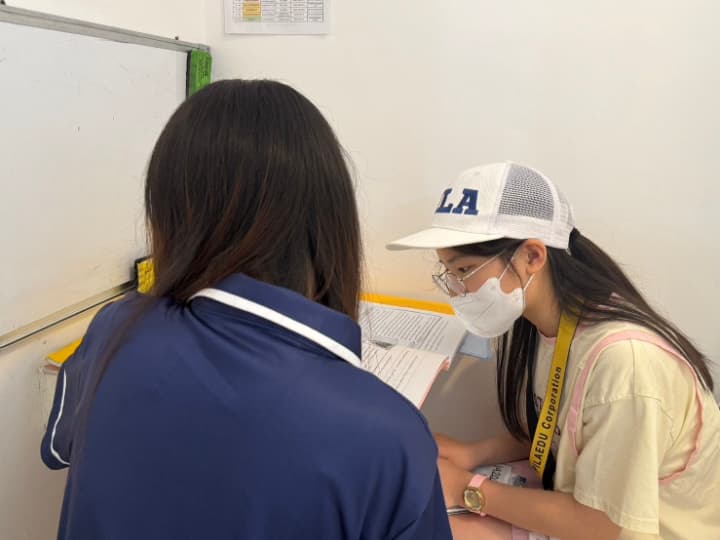 フィリピン人の講師と向かい合って、テキストを見ながら授業を受ける女の子