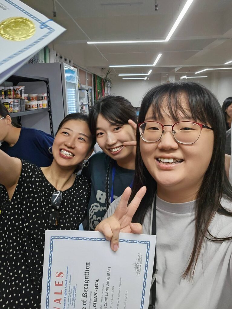 修了証を手に、友だちと写るお客様